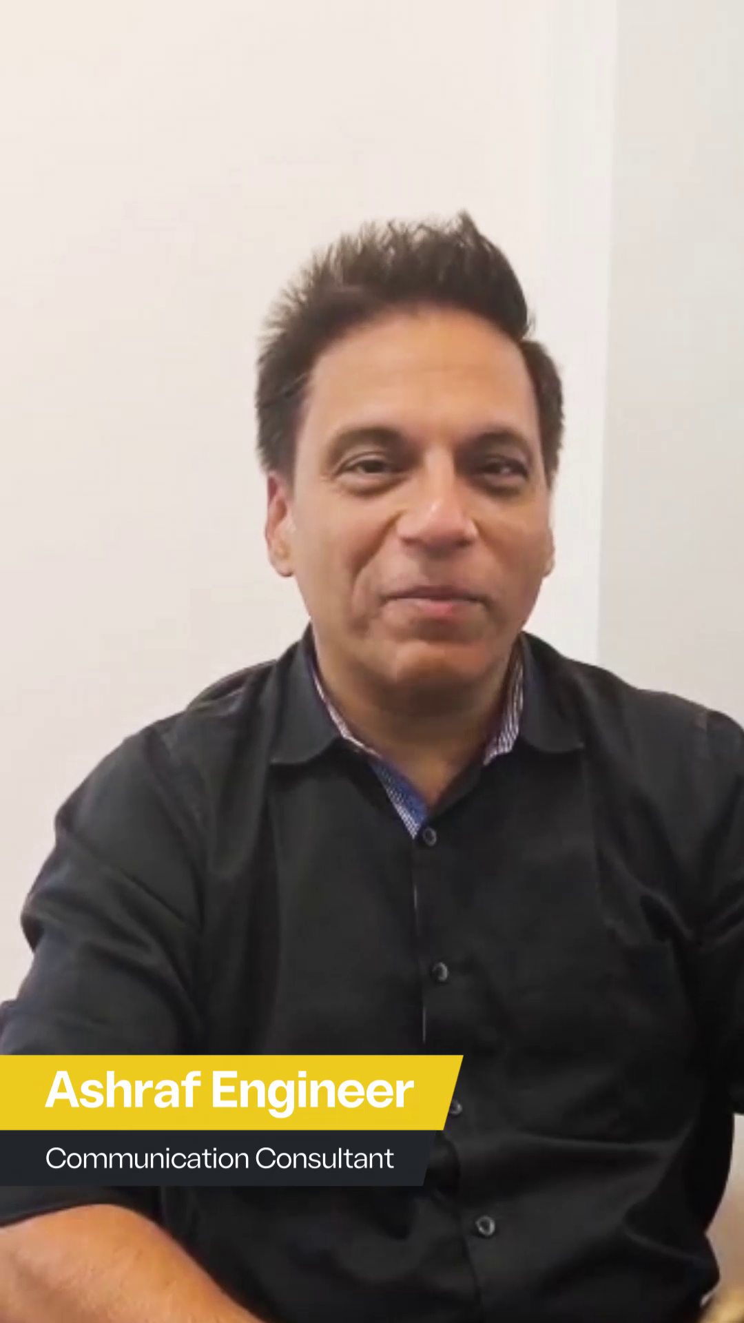 Portrait of Ashraf Engineer, Communication Consultant, smiling in a professional setting with a white background, featuring a text overlay of his name and title.
